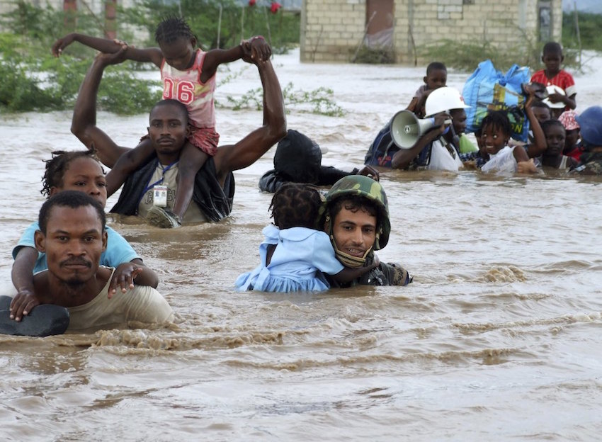 Refugiados atraviesan una corriente de agua