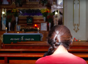 Mujer reza en capilla